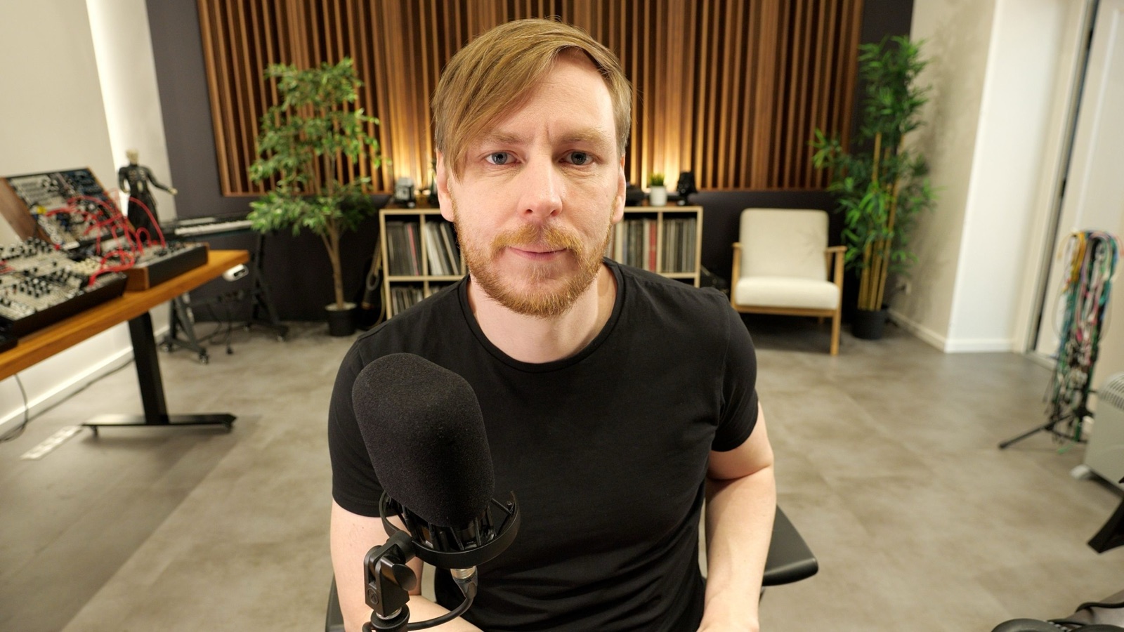 Björn Torwellen im SINEE Studio vor Modular-System und Plattenregal